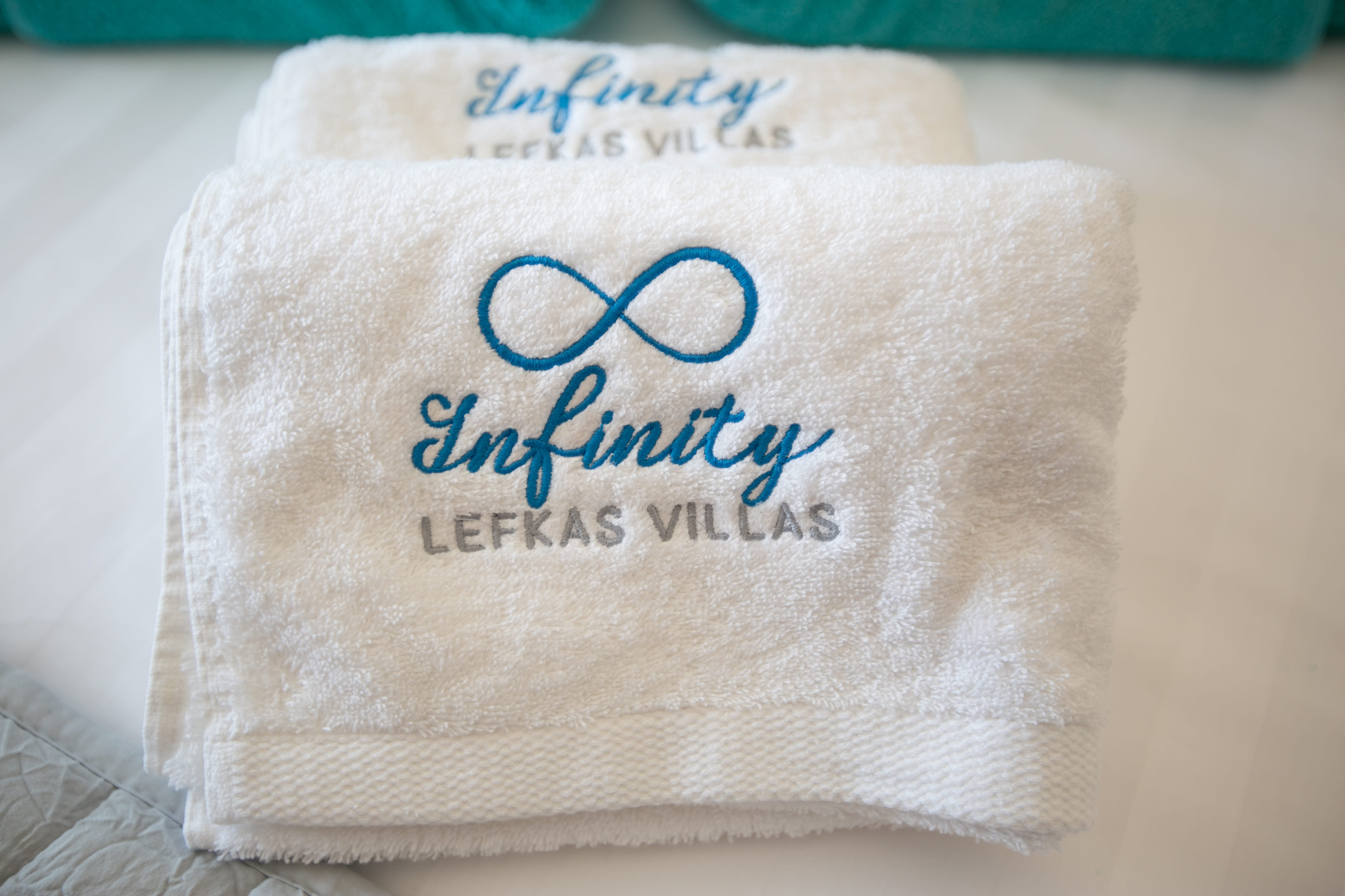 Close-up of embroidered Infinity Lefkas branded towel — Greek family hospitality detail